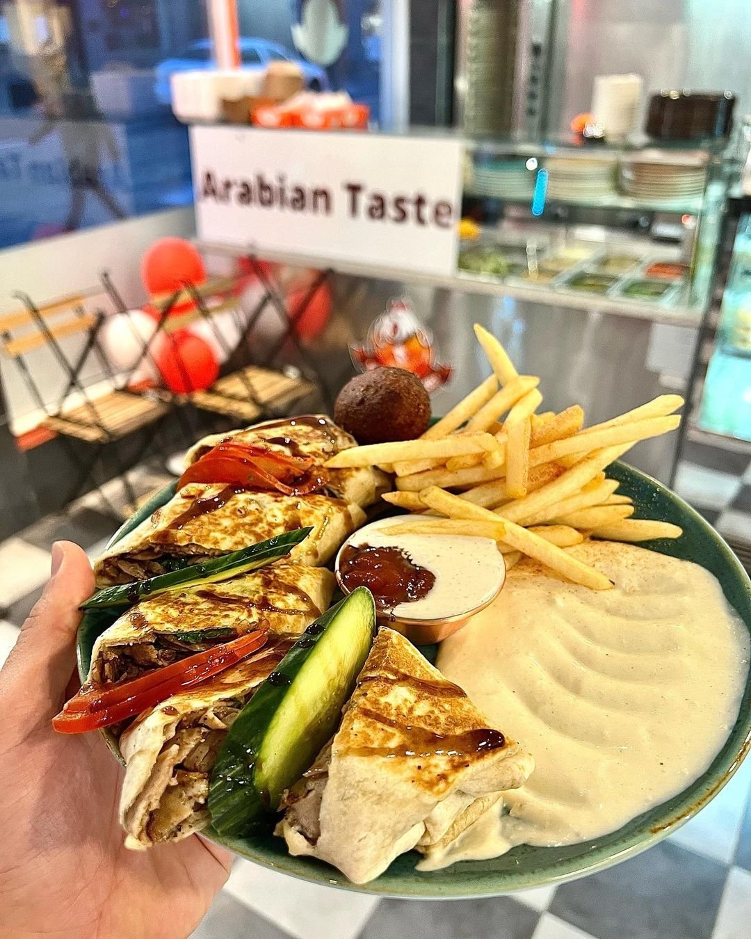 Shawarma plate with fries, hummus and fresh vegetables, served at the Arabian Taste counter